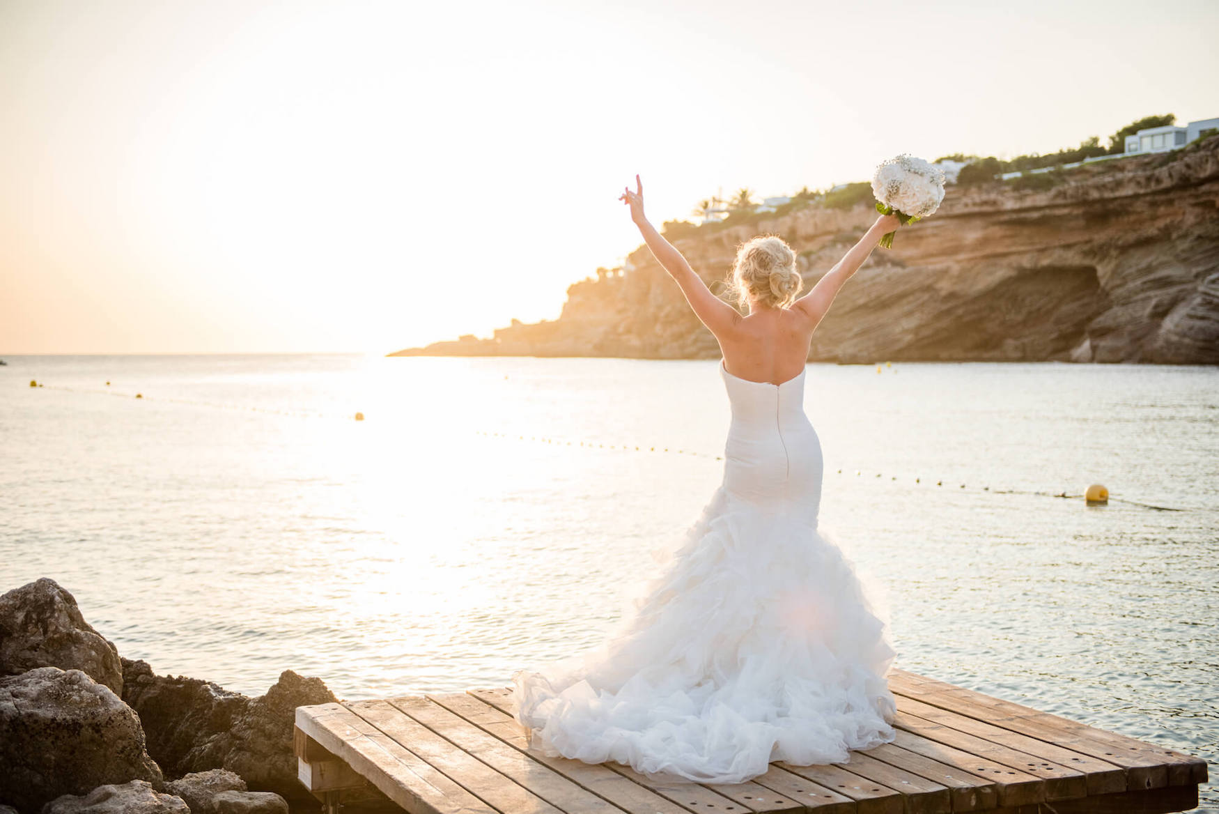 Back view of a bride in a wedding dress at sunset in Ibiza